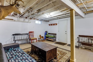Una habitación con un banco de madera, un caballo balancín, un sofá y un tapete estampado.