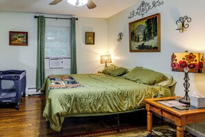 Un dormitorio con una cama, un escritorio, una silla, una lámpara y un cuadro en la pared.