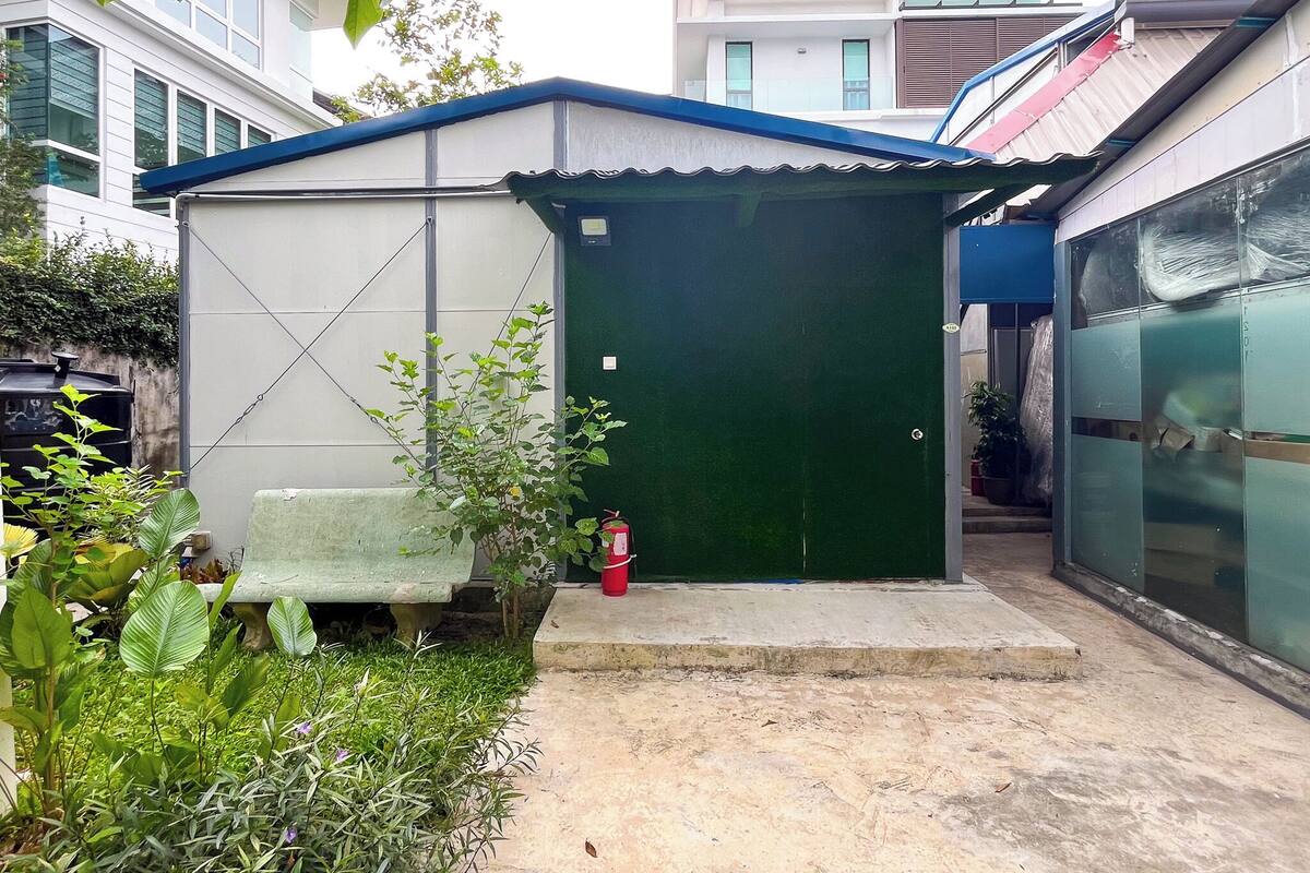 Un petit bâtiment d’un seul étage, avec une porte verte et une façade blanche.