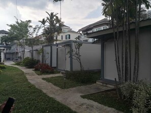 Un quartiere residenziale con case moderne, un vialetto lastricato e qualche area verde.