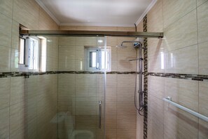 Chuveiro, toalhas de banho, sabonete, papel higiênico