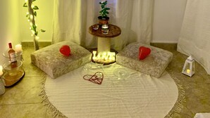Eine gemütliche Ecke mit rundem Tisch, einem Blumentopf und einer herzförmigen Dekoration.
