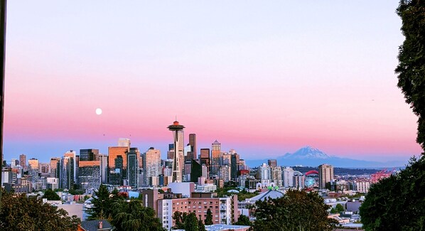 A city skyline with a prominent tower and a mountain in the background.
