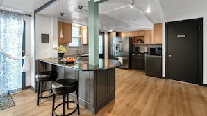 A modern kitchen with a central island, wooden cabinets, stainless steel appliances, and a "No Smoking" sign. - King Estate with attached Mid-Century Apartment & Gym. (Wichita)