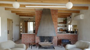 A living room with a fireplace, two sofas, and a brick wall.