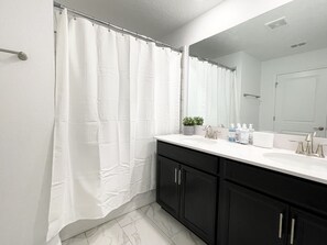 Een bad/douchecombinatie, een haardroger, een bidet, handdoeken