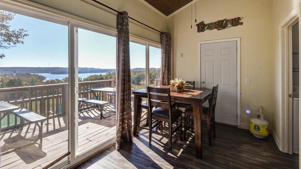 A covered dining area with a table and chairs, a view of the outdoors, and a sign indicating a "FISHING ROOM." - Hoot Owl @ Table Rock Lake - Amazing Lake Views!! - Game Room - Priced TO Rent!! (Kimberling City)