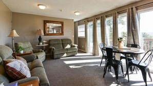 A living room with a sofa, chairs, a table, and a mirror. - Hoot Owl @ Table Rock Lake - Amazing Lake Views!! - Game Room - Priced TO Rent!! (Kimberling City)