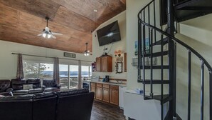 A spacious living area with a large sofa, wooden ceiling, and a view to the outside. - Hoot Owl @ Table Rock Lake - Amazing Lake Views!! - Game Room - Priced TO Rent!! (Kimberling City)