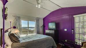 A bedroom with a bed, a TV, a window with blinds, a ceiling fan, and a view of the outdoors. - Hoot Owl @ Table Rock Lake - Amazing Lake Views!! - Game Room - Priced TO Rent!! (Kimberling City)