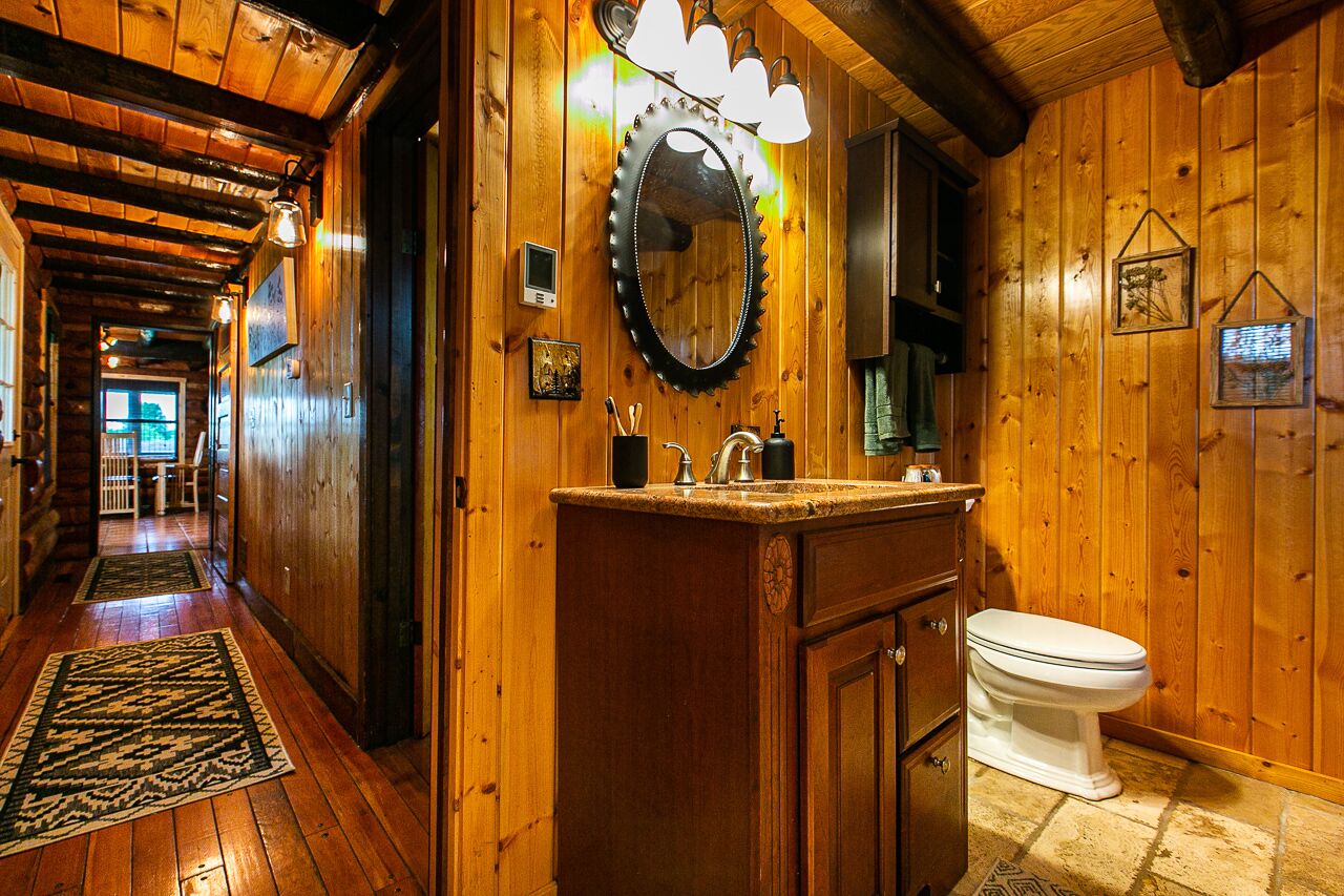 A wooden interior with a wooden floor, a sink, and a toilet.