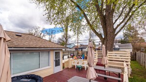 A backyard with a wooden deck, picnic tables, and a trampoline. - Luxe 7 bdr 4 Fullbath with Jacuzzi on West side Detroit (Detroit)