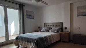 A bedroom with a bed, nightstands, a ceiling fan, and a sliding glass door. - Luxury Golf View 3Bed Penthouse, Sleeps 6, Balcony (Mar Menor Golf)
