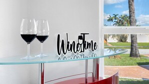 Uma mesa de vidro com duas taças de vinho e uma placa que diz 'Wine Time'.