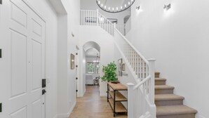 A staircase with a white railing leading to an upper level.