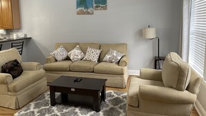 Ein Wohnzimmer mit einer Sofagarnitur, einem Couchtisch und einem Teppich.