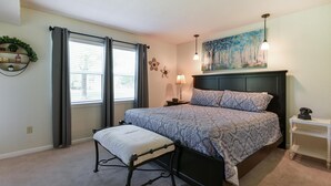 A bedroom with a bed, bedside table, lamp, and a painting on the wall. - Southern Paradise - Resort Amenities - Close to Downtown and the Branson Landing (Branson)