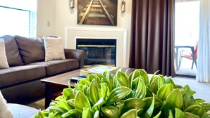 A living room with a sofa, a coffee table, a fireplace, and a large window with curtains. - Southern Paradise - Resort Amenities - Close to Downtown and the Branson Landing (Branson)
