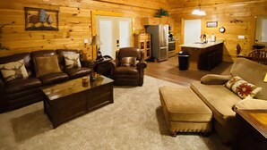 Ein gemütliches Blockhaus-Interieur mit Wohnzimmer, Küche und Essbereich.