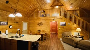 Ein Ferienhausinnenraum mit Küche, Essbereich und Wohnzimmer.