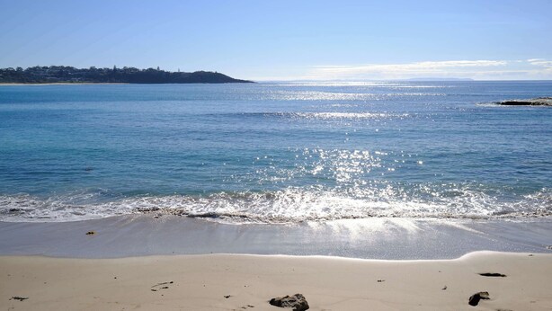 A beach with clear water, a sandy shore, and a distant landmass. - Sandy Shore Villa at Mollymook (Mollymook)