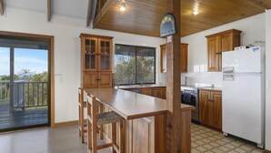 Una cocina con armarios de madera, un refrigerador blanco y un ventanal grande.