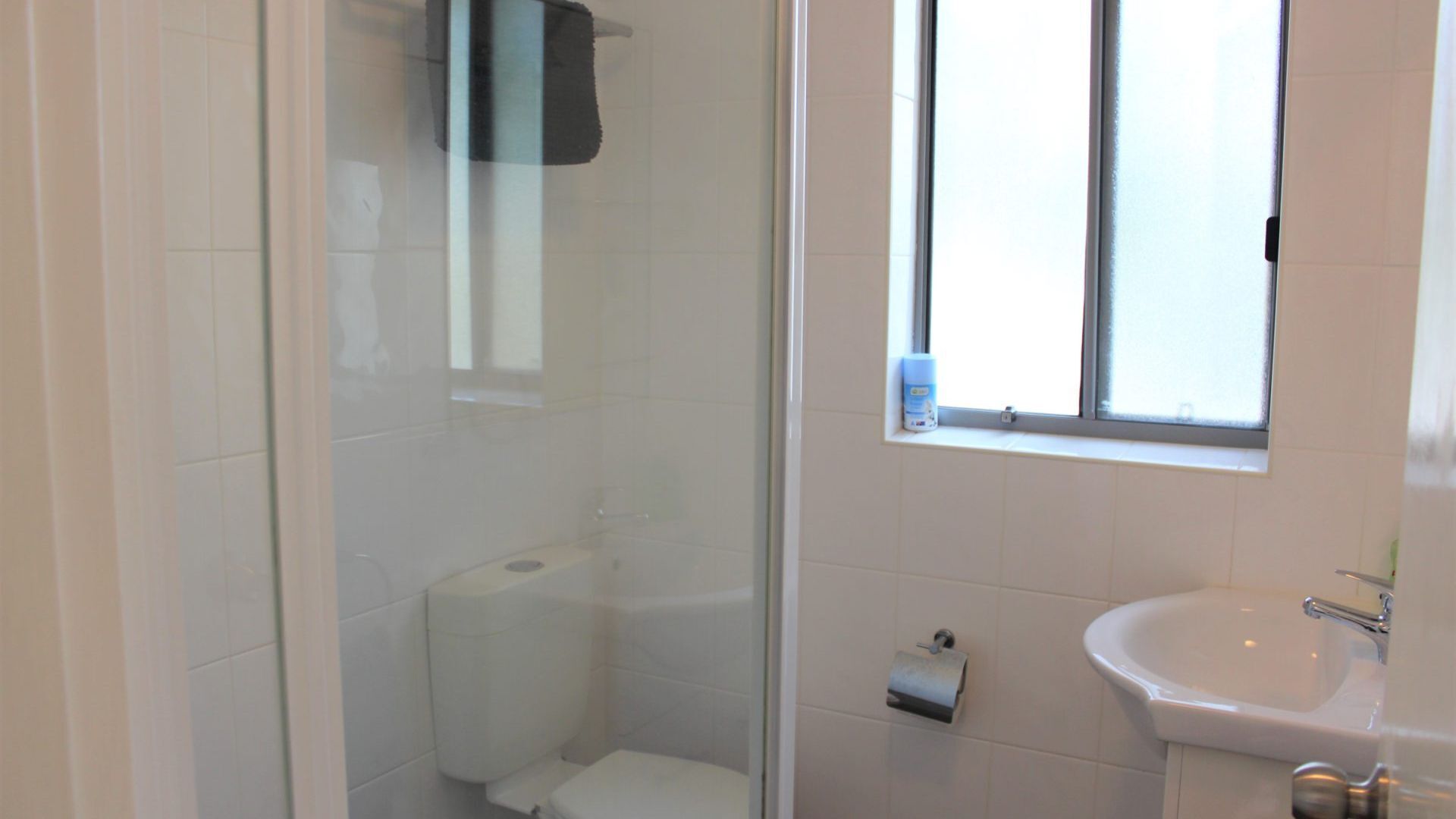 Un baño con inodoro, lavamanos y ventana.