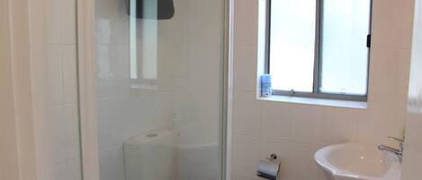 Un baño con inodoro, lavamanos y ventana.