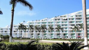Un hôtel à plusieurs étages au design moderne, doté de balcons et de grandes fenêtres.