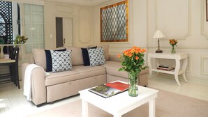 A living room with a beige sofa, a white coffee table, and a vase with flowers. - Terraza de Hamburgo By The Local Way (Mexico City)