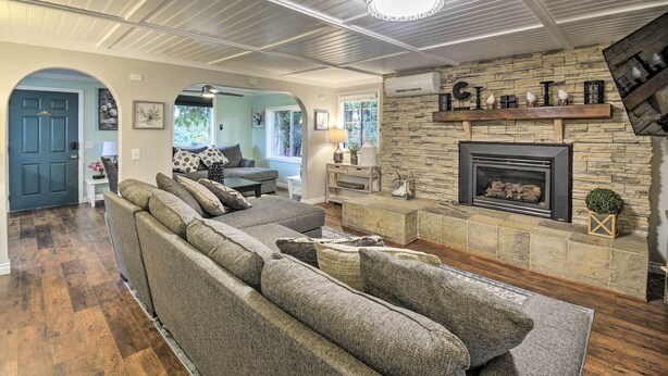 A spacious living room with a stone fireplace, a large sectional sofa, and a wooden ceiling. - Spacious Home w/ Yard, 20 Miles to Olympic NP (Sequim)
