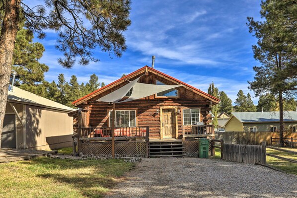 A rustic log cabin with a porch, a covered entryway, and a gravel driveway. - Tasteful Log Cabin Retreat on Lake Pagosa! (Pagosa Springs)