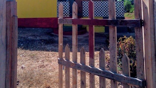 A colorful building with a sign that reads "Relax N Sunshine." -  Relax N SunShine 
Peaceful, Retreat (May Pen)