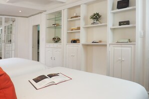 A neatly organized bedroom with a large bed, a bedside table with a book, and built-in shelving with decorative items. - Pasaje de Hamburgo By The Local Way (Mexico City)