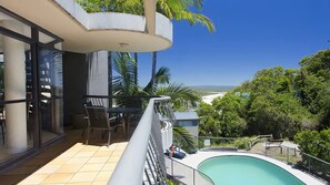 Enjoy a refreshing view of the pool and surrounding landscape from this balcony.