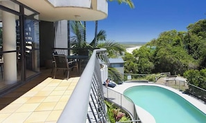 Ein Balkon mit Pool, Sitzgelegenheit im Freien und Blick auf die Landschaft.