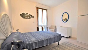 A bedroom with a bed, a chair, a dresser, and a wall decoration. - Just 300 meters from the sandy beach (Marina di Campo)