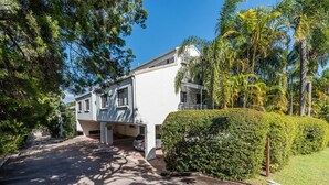 Ein Wohnhaus mit Auffahrt, Garage und gepflegtem Heckenstreifen.