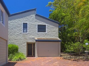 A two-story house with a garage, a small window, and a door.