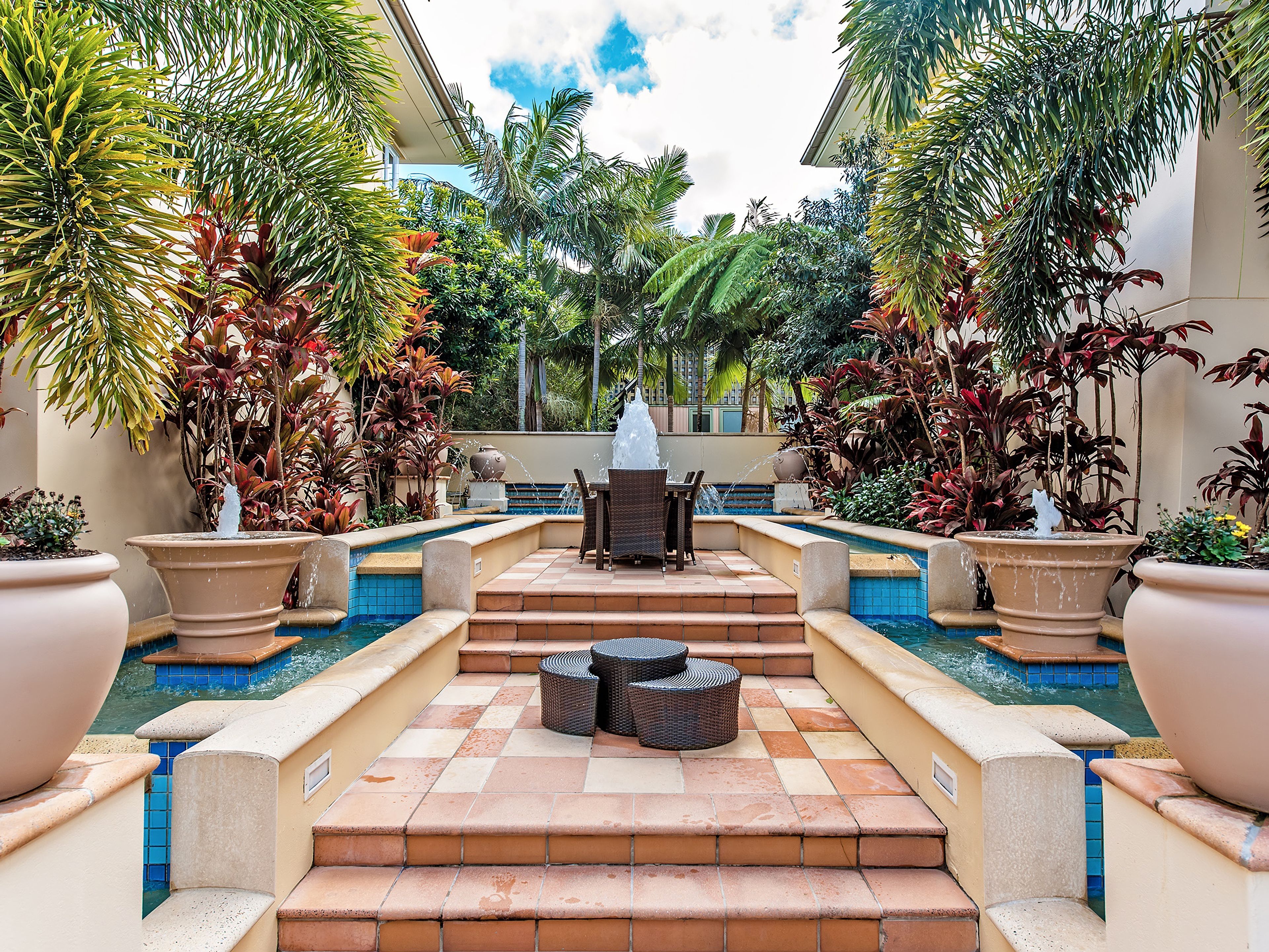 A pool area with a seating arrangement and a fountain.