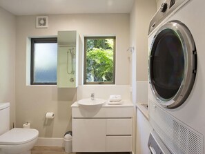 Un bagno compatto con WC, lavandino e lavatrice integrata.