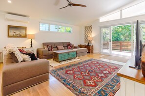 A spacious living room with a sofa, a coffee table, and a television.