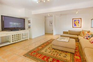 A living room with a television, sofa, and a patterned rug.