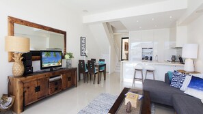 Relax in this stylish living space with a sofa, dining area, and flat-screen TV.