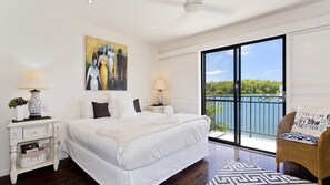 Relax in a spacious bedroom with a large bed, two bedside tables, and a balcony view.