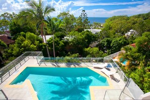 A swimming pool with a clear view of the ocean in the background.