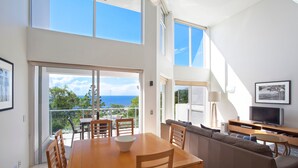 Un intérieur moderne comprenant un coin repas, un canapé et un téléviseur.