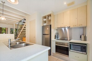 Una cocina moderna con electrodomésticos de acero inoxidable, horno empotrado y microondas.