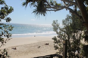 A beach with clear skies, calm water, and a few people.
