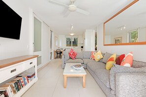 A modern living room with a sofa, coffee table, and a TV.